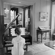 Woman in evening dress playing the harpsichord, Fenton House, London, 1960-1965
