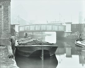 Man mooring a barge by a river bank, Poplar, London, 1905. Artist: Unknown.