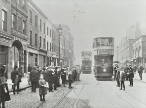 Pedestrians and trams in Commercial Street, Stepney, London, 1907. Artist: Unknown.