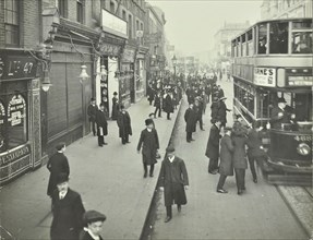 People rushing to get on a trolley bus at 7.05 am, Tooting Broadway, London, April 1912. Artist: Unknown.