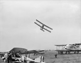Avro 504 biplane flying very low over parked aircraft at the RAF Pageant, Hendon, London, 1927