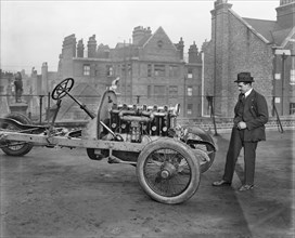 Italian racing driver Giulio Foresti with the chassis of a car, London, 1918-1919