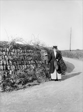 Postwoman emptying a postbox at an unidentified location in Kerrier, Cornwall, 1901