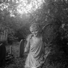 Statue of a child angel with a missing arm, Highgate Cemetery, Hampstead, London, 1987