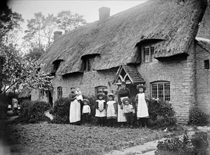 Women and children outside a thatched cottage, Marsh Gibbon, Buckinghamshire, 1904