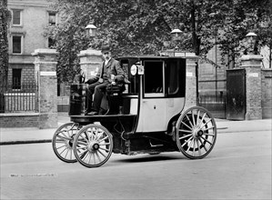 An electric motor cab and driver, London, c1897-c1900