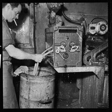 Man smoking whilst operating an Ernest A Bitterling Ltd stripper crusher machine, 1966-1974