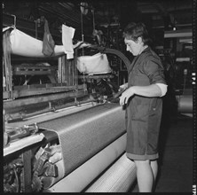 Weaver preparing a shuttle for use in a power loom, 1966-1974