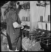 Woman operating a cop winding frame in a textile mill, 1966-1974