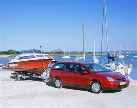 2002 Citroen C5 hdi towing a boat by harbour. Artist: Unknown.