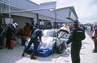 1999 Porsche 911 GT2 in pits.FIA GT Silverstone 500. Artist: Unknown.