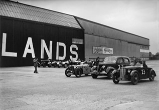 Morris, Ford V8 and MG PA Midget cars at the MCC Members Meeting, Brooklands, 10 September 1938. Artist: Bill Brunell.