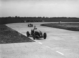 Rapier Special Racing single seater leading a MG in a race on the Campbell Circuit at Brooklands. Artist: Bill Brunell.