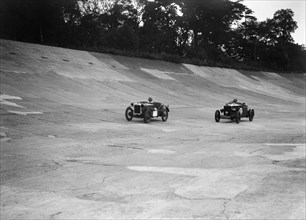Austin Ulster leading a Windsor on the banking at Brooklands. Artist: Bill Brunell.