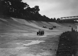 Cars racing on the Members Banking at a JCC Members Day, Brooklands. Artist: Bill Brunell.