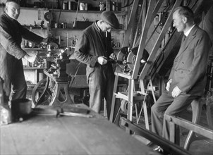 Geoffrey Baker with two other men in a workshop. Artist: Bill Brunell.