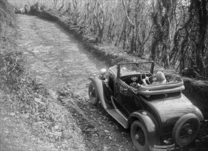 Kitty Brunell driving a 1930 Ford Model A 2-seater, 1931. Artist: Bill Brunell.