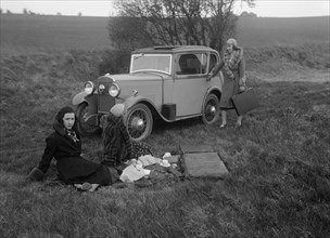 Three women having a picnic during a road test of a Triumph Scorpion, 1931. Artist: Bill Brunell.