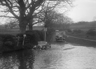 972 cc Singer Le Mans driving through water during a motoring trial, 1936. Artist: Bill Brunell.