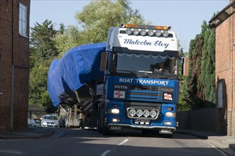DAF 95 XF wide load truck carrying a life boat through a small village