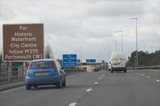 Traffic on M27 Motorway with brown tourist information sign