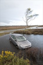 Ford Focus in flooded ditch after losing control on wet road 2012 Artist: Unknown.