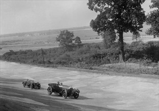 Bentley of FE Elgood and MG Magna of MB Watson racing at a MCC meeting, Brooklands, Surrey, 1933. Artist: Bill Brunell.