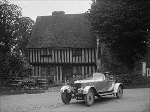 Two women in a AC motor car in front of a Tudor house, c1930s Artist: Bill Brunell.