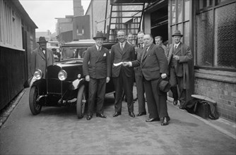Group of men with a Triumph Super Seven, c1930(?). Artist: Bill Brunell.