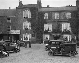 Cars parked outside the Fleece Hotel, Thirsk, Yorkshire, Ilkley & District Motor Club Trial, 1930s. Artist: Bill Brunell.