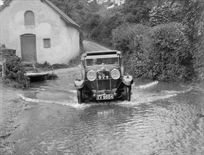 Kitty Brunell fording the River Exe in a Talbot 14/45 sportsman's coupe, Winsfors, Somerset, c1930s. Artist: Bill Brunell.