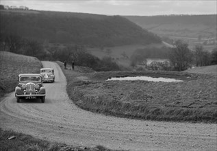 Rover of BN Wilmott and Jaguar SS of Dr AR Gray competing in the RAC Rally, 1939. Artist: Bill Brunell.