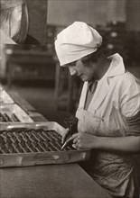 A woman uses a piping bag to decorate chocolates, Rowntree factory, York, Yorkshire, 1932. Artist: Unknown