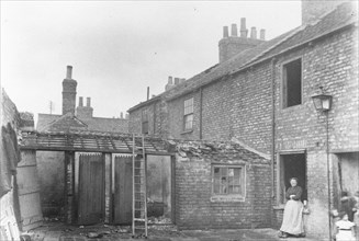 A woman stands in the back yard of a house, York, Yorkshire, 1923. Artist: Unknown