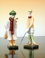 Ceramic figures of a golfer and caddy, Austrian, c1910. Artist: Unknown