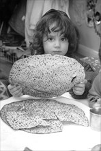 Jewish child holding Passover matzot, Edgware, London, 29 March 1991. Artist: John Nathan