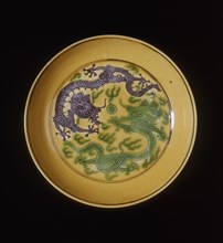 Green and aubergine dragons on yellow ground saucer, Guangxu period, Qing dynasty, China, 1875-1908. Artist: Unknown