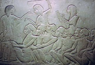 Detail of an Egyptian stele showing an overseer, slaves and scribe. Artist: Unknown