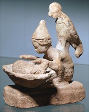 Greek terracotta of a haruspex inspecting pig's entrails. Artist: Unknown