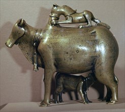 Cast bronze zebu-cow suckling her calf while a lion attacks her back, 13th century. Artist: Unknown