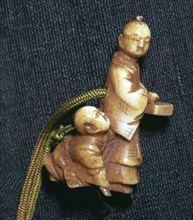 Japanese Netsuke of a man and boy at new year, 19th century. Artist: Unknown