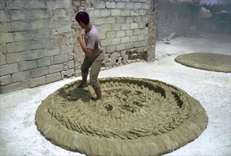 Treading clay for pottery in Tunisia. Artist: CM Dixon Artist: Unknown