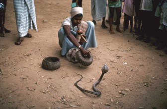 Snake charmer with cobra, in Sri Lanka. Artist: Unknown