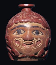 Greek terracotta scent bottle in the shape of a gorgon's head made in Rhodes. Artist: Unknown