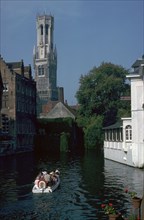 Canal, old houses, and the Belfrey of the Tour Des Halles in Bruges. Artist: Unknown