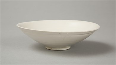 A shallow cream glazed bowl with rolled rim andraised footrim, Tang dynasty, c.800-900. Artist: Unknown.