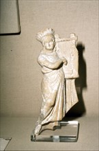 Greek Terracotta, Woman playing Kithera with plectrum, 3rd century BC-2nd century BC Artist: Unknown.
