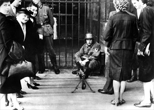 Civilians in front of a German guard post with a machine gun, Paris, June 1940. Artist: Unknown