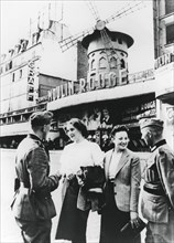 German soldiers chatting up French women outside the Moulin Rouge, occupied Paris, June 1940. Artist: Unknown