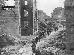 American soldiers passing through the ruins of Varennes, Meuse-Argonne Offensive, France, 1918. Artist: Unknown